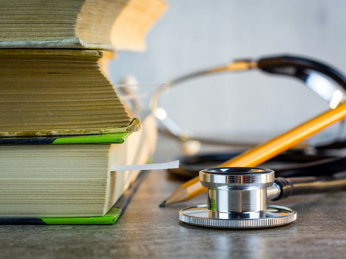 Estetoscopio junto a libros de medicina
