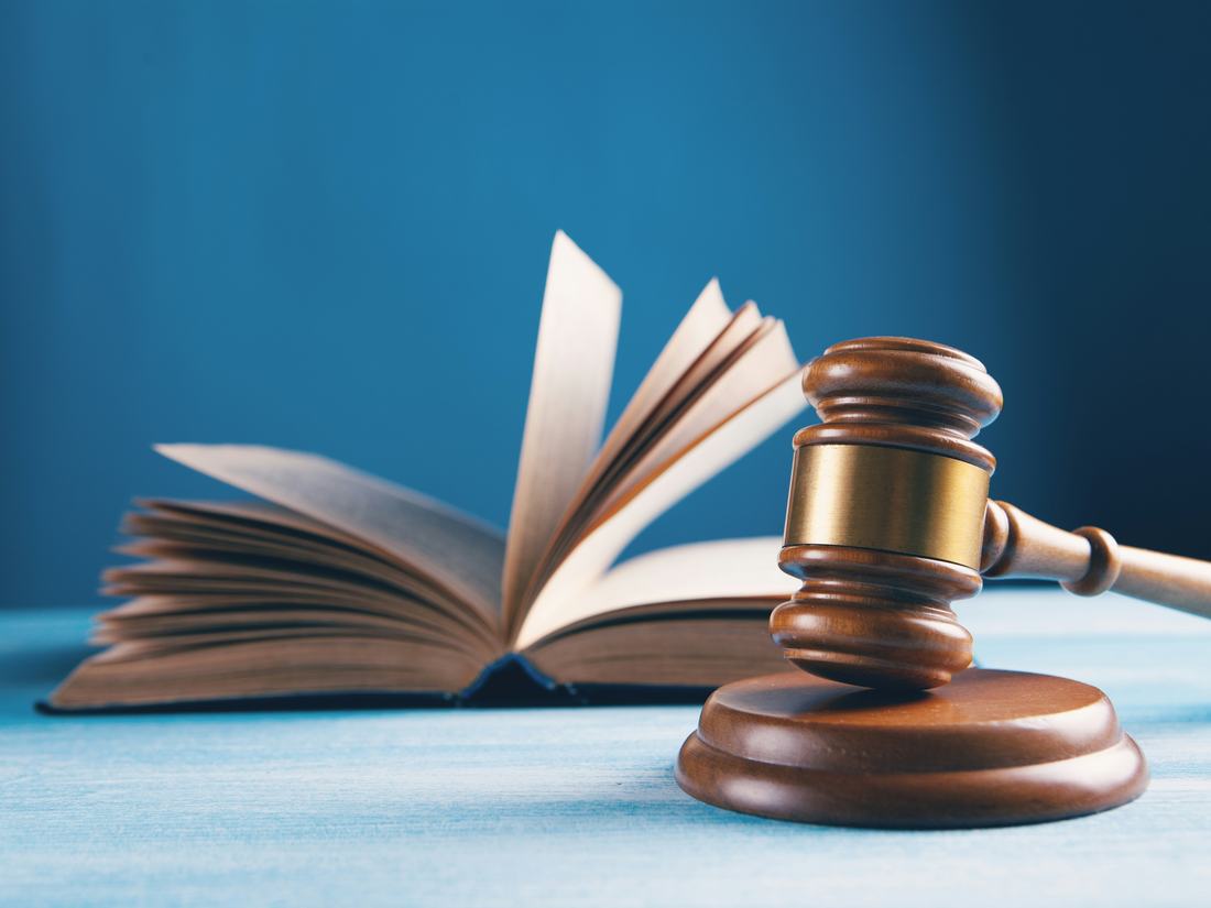 Mazo de juez junto a un libro de leyes
