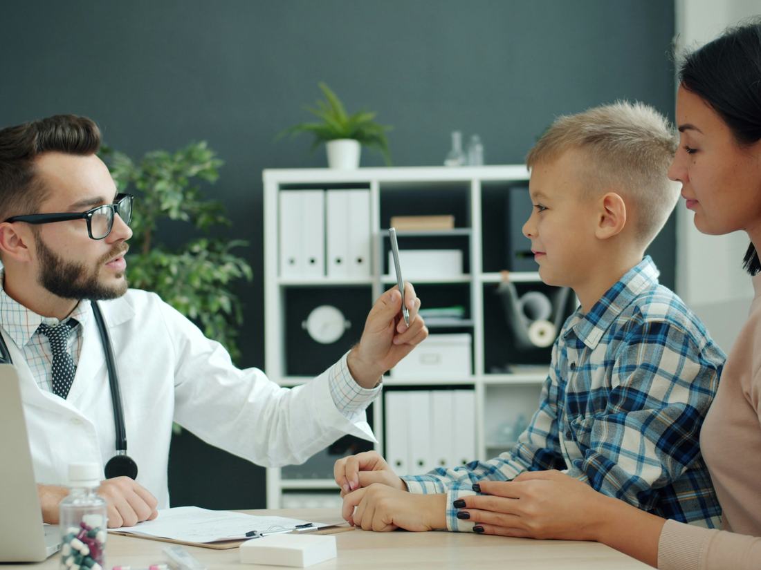 Médico conversando con un niño y su madre
