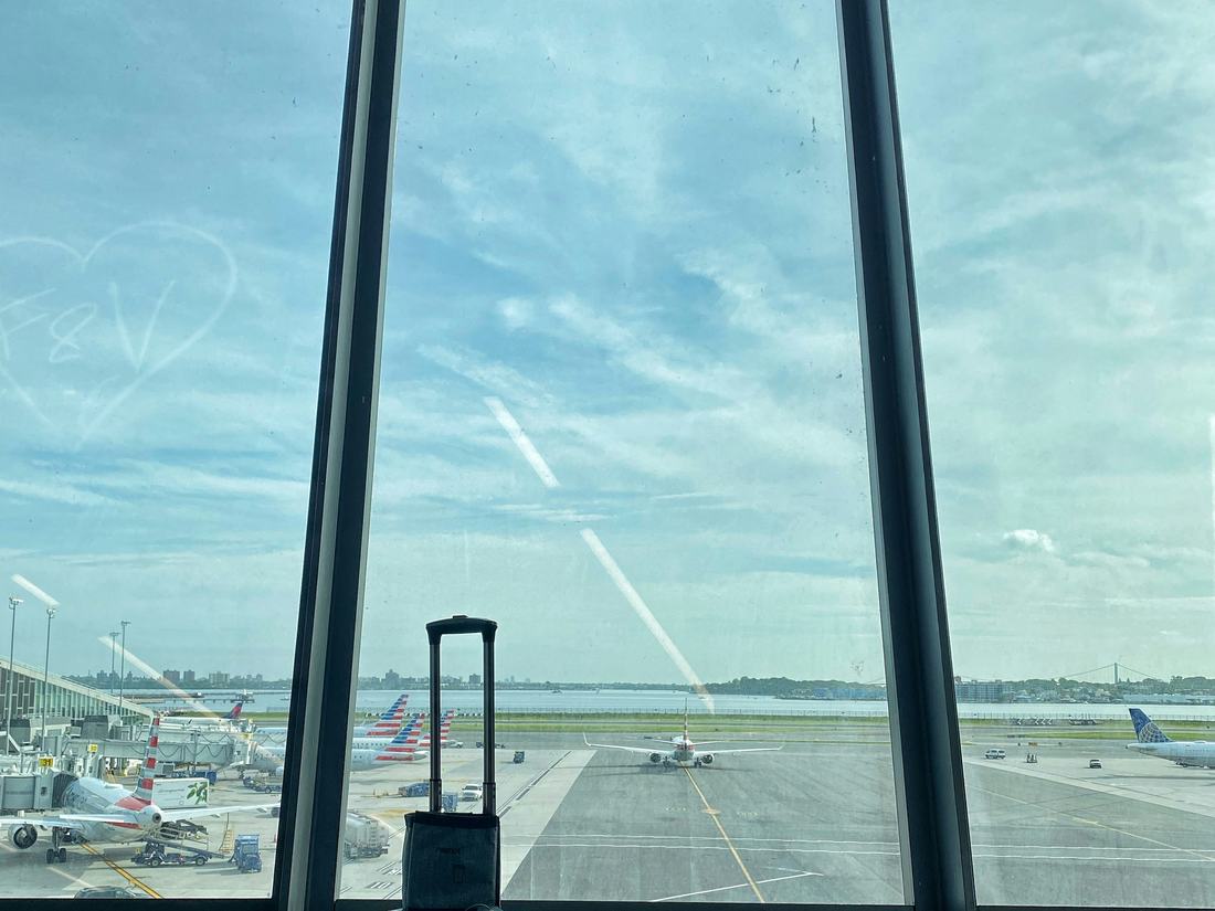 Valija de viaje frente a la ventana de un aeropuerto